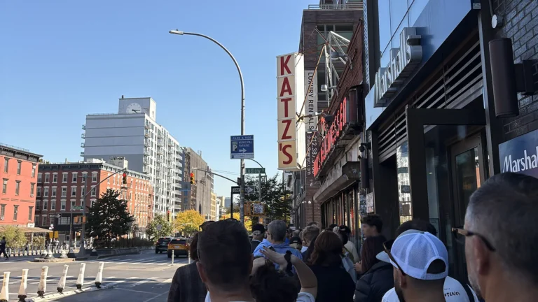 Queue outside Katz’s Delicatessen in NYC, showing eager diners waiting to enter the iconic deli.