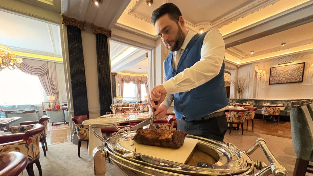 Tableside carving of roast beef by a waiter at The Game Bird, London.