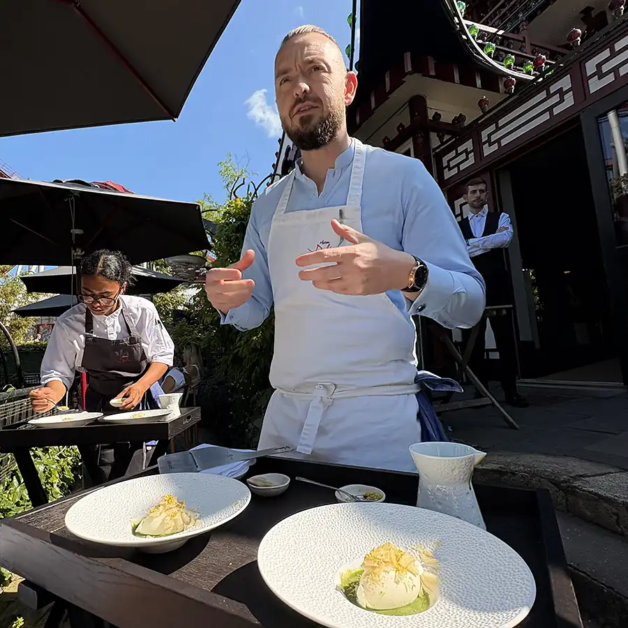 Chef Tristin Farmer presenting a dish during the Maison Dali pop-up at Tivoli Gardens in Copenhagen, June 2025