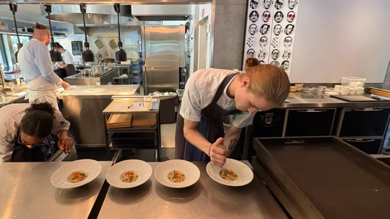 Chef plating king crab with fermented pineapple and trout roe in the kitchen at Maison Dali’s Copenhagen pop-up, June 2025