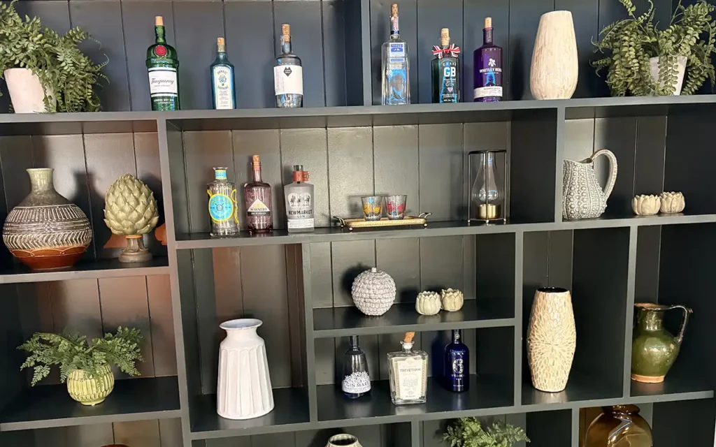 Display shelves with gin bottles and decorative items at Dormy House