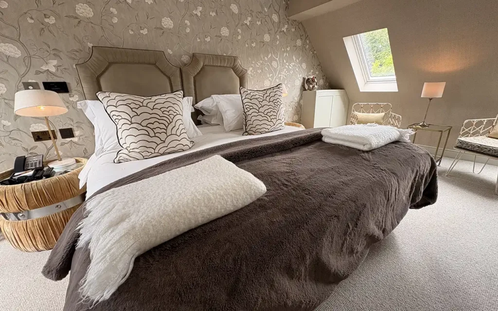 Bedroom at Dormy House with twin headboards and patterned cushions