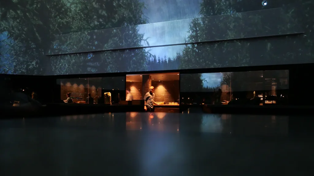 Alchemist restaurant dome kitchen with forest projection and chef silhouette in Copenhagen
